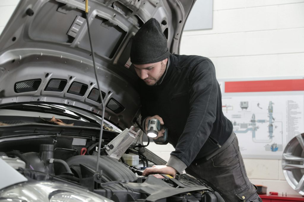 Auto mechanic inspecting a car engine