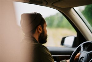 A man leans out of a car window while driving, highlighting the importance of Roadworthy Certificate Rowville.